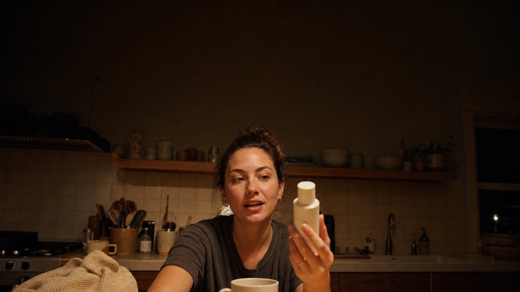 A creator filming a piece to camera in a kitchen.